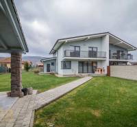 Rodinný dům na Krátké ulici v Spišském Bystrém s udržovaným trávníkem a přístřeškem.