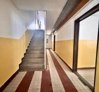 Vstupní chodba s dlažbou v 3-pokojovém bytě, schodiště a barevné stěny.