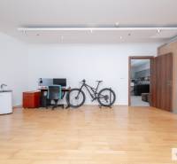 Interiér 3-pokojového bytu s podlahou s dřevěným dekorem, pracovním stolem a kolem.