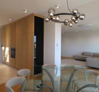 Obývací pokoj s jídelním stolem, pohovkou a svítidlem ve 4pokojovém bytě, podlaha s dřevěným dekorem.