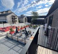 Exteriér Náměstí u Sýpky v Bratislavě - Jarovce s terasou a cihlovými budovami.