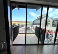 Výhled z 2pokojového bytu na balkon s podlahou s dřevěným dekorem.