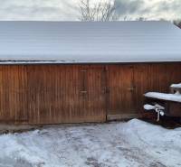 Na fotografii z Ochodnice je dřevěný skladný přístřešek u rodinného domu se sněhovou pokrývkou.