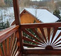 Sněžený výhled z dřevěného balkónu rodinného domu v Ochodnici na ulici Ochodnica.