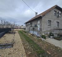 Rodinný dům v Hernádkaku se zahradou, štěrkovou příjezdovou cestou a dřevěnými prvky.