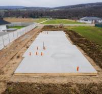 Základy rodinného domu v Sokolovcích obklopené venkovskou krajinou a sousedními domy.