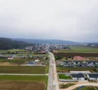 Letecký pohled na vesnici Sokolovce s rodinnými domy a rozlehlými poli.