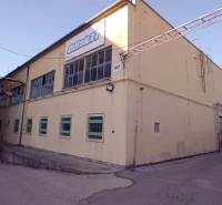 Budova na Coburgově ulici v Trnavě, sklady a haly, žlutý exteriér, průmyslová architektura.