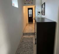 Úzká chodba v rodinném domě, kobereček se vzorem a výzdoba stěn.