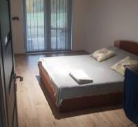 Ložnice v rodinném domě s postelí a podlahou s dřevěným dekorem.