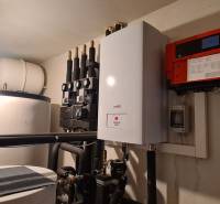 Technické zařízení v rodinném domě s kotlem a nádrží na vodu.