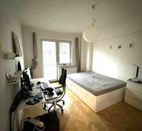 Ložnice ve 4-pokojovém bytě s pracovním stolem a postelí, podlaha s dřevěným dekorem.