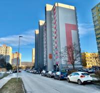 Ulice Drobného v Bratislavě-Dúbravce s výškovými paneláky a zaparkovanými auty, 1-pokojový byt.