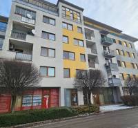 Budova s obchodními prostory na Budovatelské ulici v Šaľe se zimním nádechem.