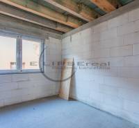 Budova s bílými stěnami a velkým okenním otvorem.