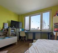 Dětský pokoj ve 3-pokojovém bytě s podlahou s dřevěným dekorem a výraznými zelenými stěnami.