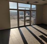 Prostorný interiér s velkými okny a dlažbou ve skladech a halách.