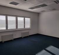 Interiér skladů a hal s modrým kobercem, velkými okny a bílými stěnami.