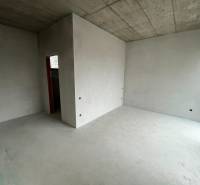 Interiér s betonovým stropem a okny v rodinném domě, připravený k dokončení.