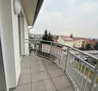 Balkon s dlážděnou podlahou a výhledem na ulici Školskou v Chorvátském Grobu.