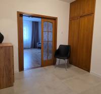 Interiér 3-pokojového bytu s posuvnými dveřmi a podlahou s dřevěným dekorem.