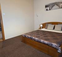 Ložnice v 3-pokojovém bytě se stylovou postelí, zářivým povlečením a příjemným kobercem.