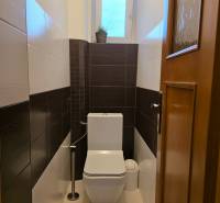 Útulná toaleta se světlými stěnami a oknem v 3-pokojovém bytě.