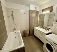 Koupelna s vanou, dvojitým umyvadlem a pračkou ve 3-pokojovém bytě.