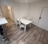 1-pokojový byt s podlahou s dřevěným dekorem a jídelním stolem.