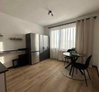 Kuchyně s podlahou s dřevěným dekorem a stolem v 1-pokojovém bytě.