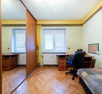 Pokoj s podlahou s dřevěným dekorem, stolem a skříní ve 3-pokojovém bytě.