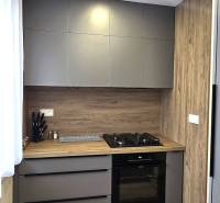 Kuchyně ve 3-pokojovém bytě s moderními spotřebiči a podlahou s dřevěným dekorem.