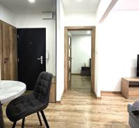 Interiér 3-pokojového bytu s podlahou s dřevěným dekorem a stylovým stolem.