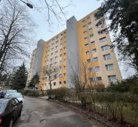 Bytový dům na Chabenecké ulici v Banské Bystrici s parkovištěm a stromy.