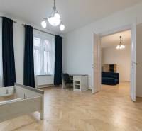 Interiér 3-pokojového bytu s podlahou s dřevěným dekorem, nábytkem a lustrem.