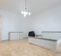 Ložnice s postelí, nábytkem a podlahou s dřevěným dekorem ve 3-pokojovém bytě.