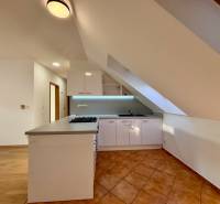 Kuchyně v 2-pokojovém bytě s kuchyňskou linkou a podlahou z keramické dlažby.