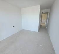 Rekreační apartmán s bílými stěnami a základní podlahou bez dekoru.