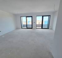 Interiér rekreačního apartmánu s výhledem přes velká okna na moře.