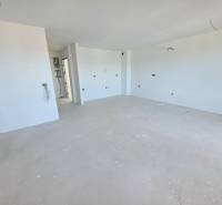 Rekreační apartmán s čistými bílými stěnami a prostornou podlahou s dřevěným dekorem.