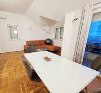 Jídelna a obývací pokoj v rekreačním apartmánu s podlahou s dřevěným dekorem.