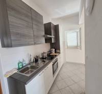 Kuchyně rekreačního apartmánu s moderním vybavením a oknem, které osvětluje prostor.