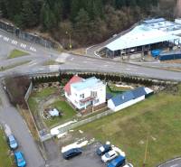 Rodinný dům na ulici SNP v Považské Bystrici, obklopený zelenými plochami a křižovatkou.