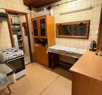 Kuchyně v chatě s plynovým sporákem, dřevěným dekorem a kuchyňskou linkou.