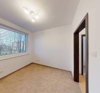 Pokoj s rozsvícenou lampou a kobercem ve 4pokojovém bytě.