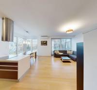 Obývací pokoj spojený s kuchyní a podlahou s dřevěným dekorem ve 4pokojovém bytě.