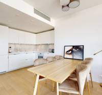 Kuchyně v 3-pokojovém bytě s podlahou s dřevěným dekorem, jídelním stolem a lampou.