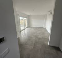 Obývací pokoj v 3-pokojovém bytě s terasou a šedou dlažbou.