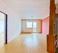 Prostorný interiér 3pokojového bytu s podlahou s dřevěným dekorem a balkónem.