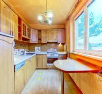 Kuchyně s dřevěnými skříňkami a podlahou s dřevěným dekorem v 3pokojovém bytě.